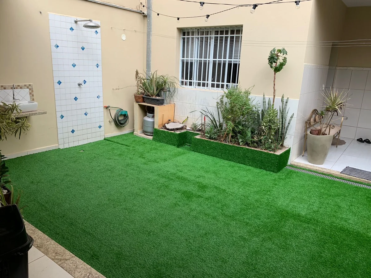 Área externa com playground e grama sintética decorativa